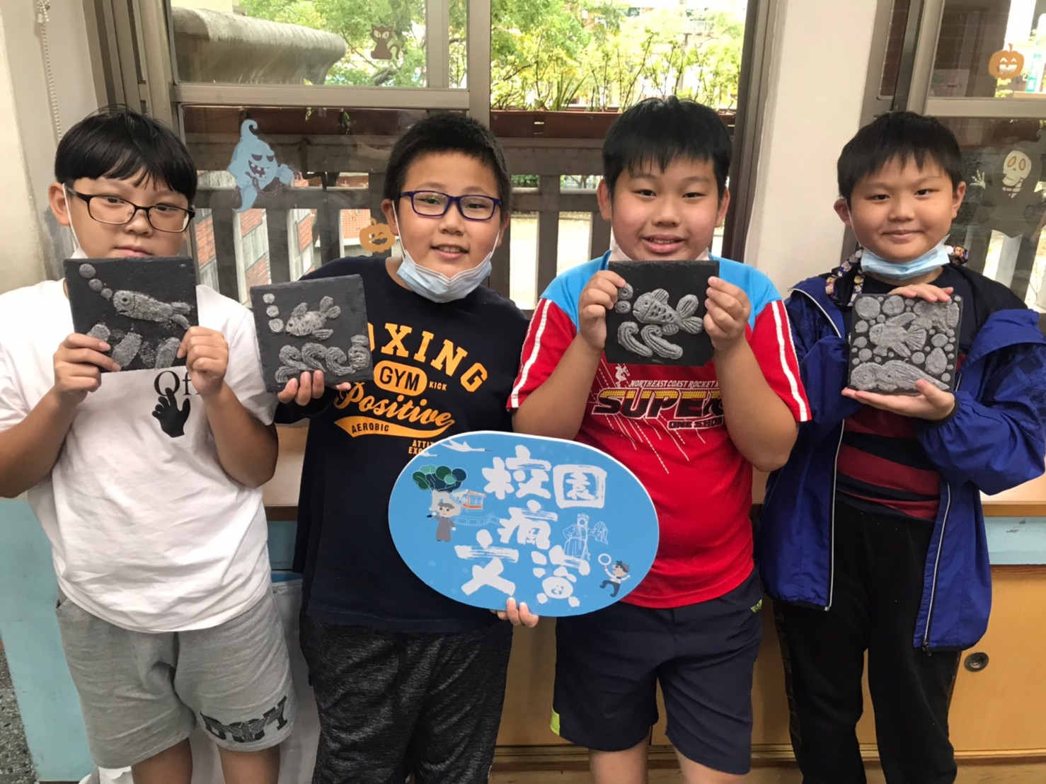 四名男同學與自己拿出自己得意的作品進行合影